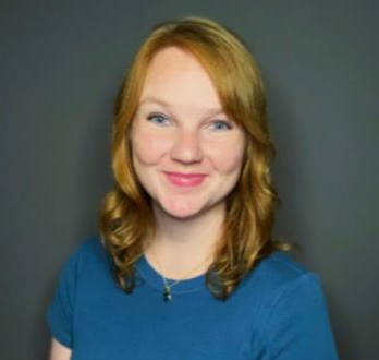 Lauren in front of a grey backdrop in a blue shirt