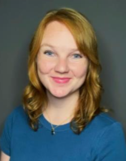 Lauren in front of a grey backdrop in a blue shirt