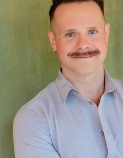 Jamey Grisham, a white man in a blue button up. He has a mustache. 